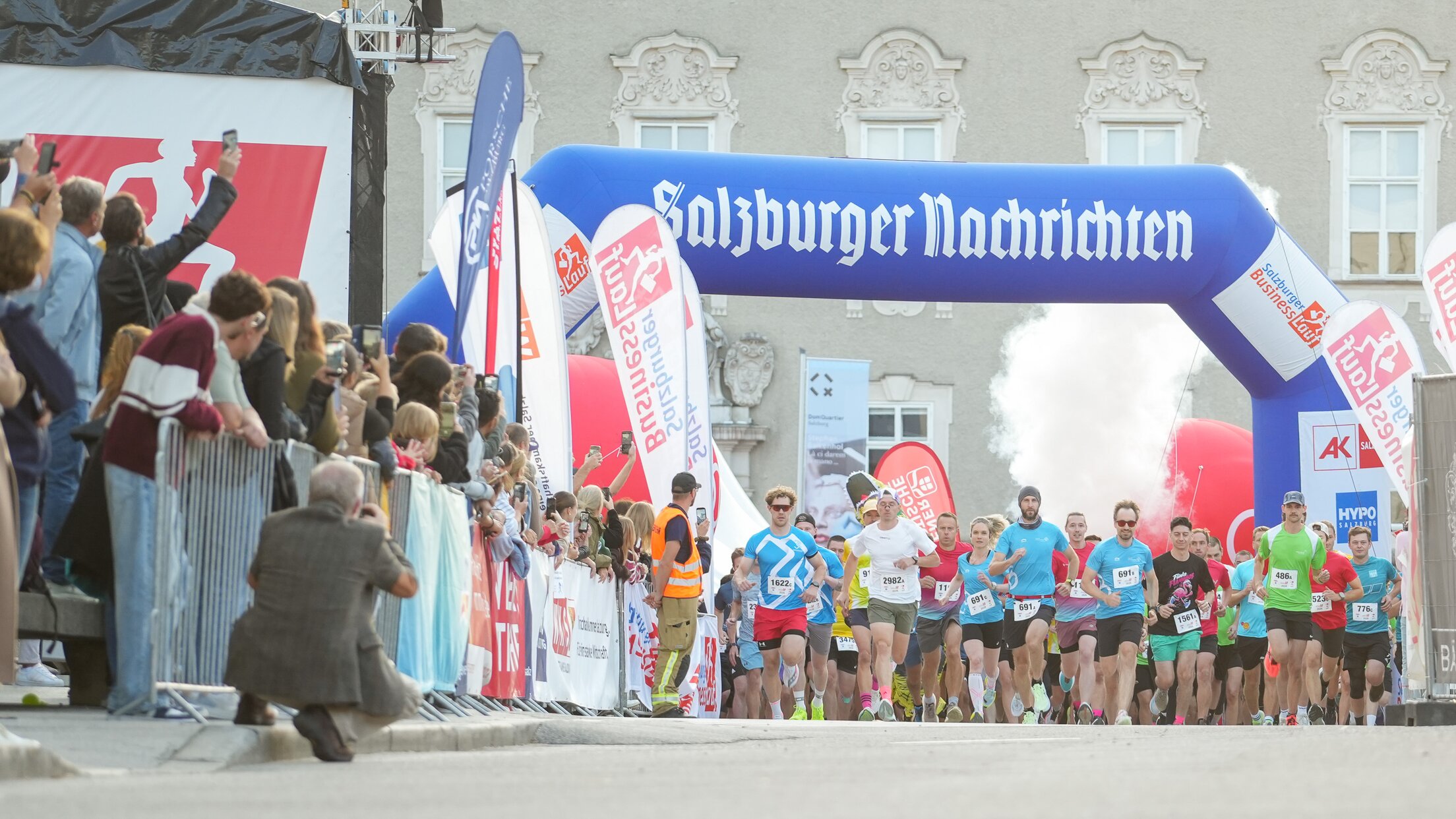 Salzburger Nachrichten Lauf: Läufer starten unter blauem Torbogen in Salzburg