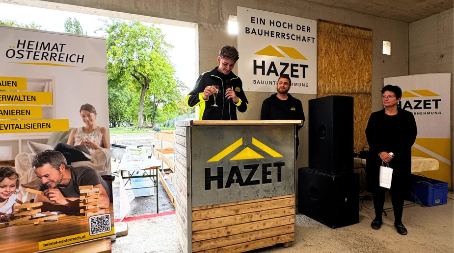 HAZET Baunternehmung: junger Mann mit Sektglas, Mann mit Bart und Frau in Schwarz bei Veranstaltung