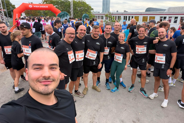 Läufer vor Wien Energie Startbogen bei einem Lauf in Wien mit Startnummern.